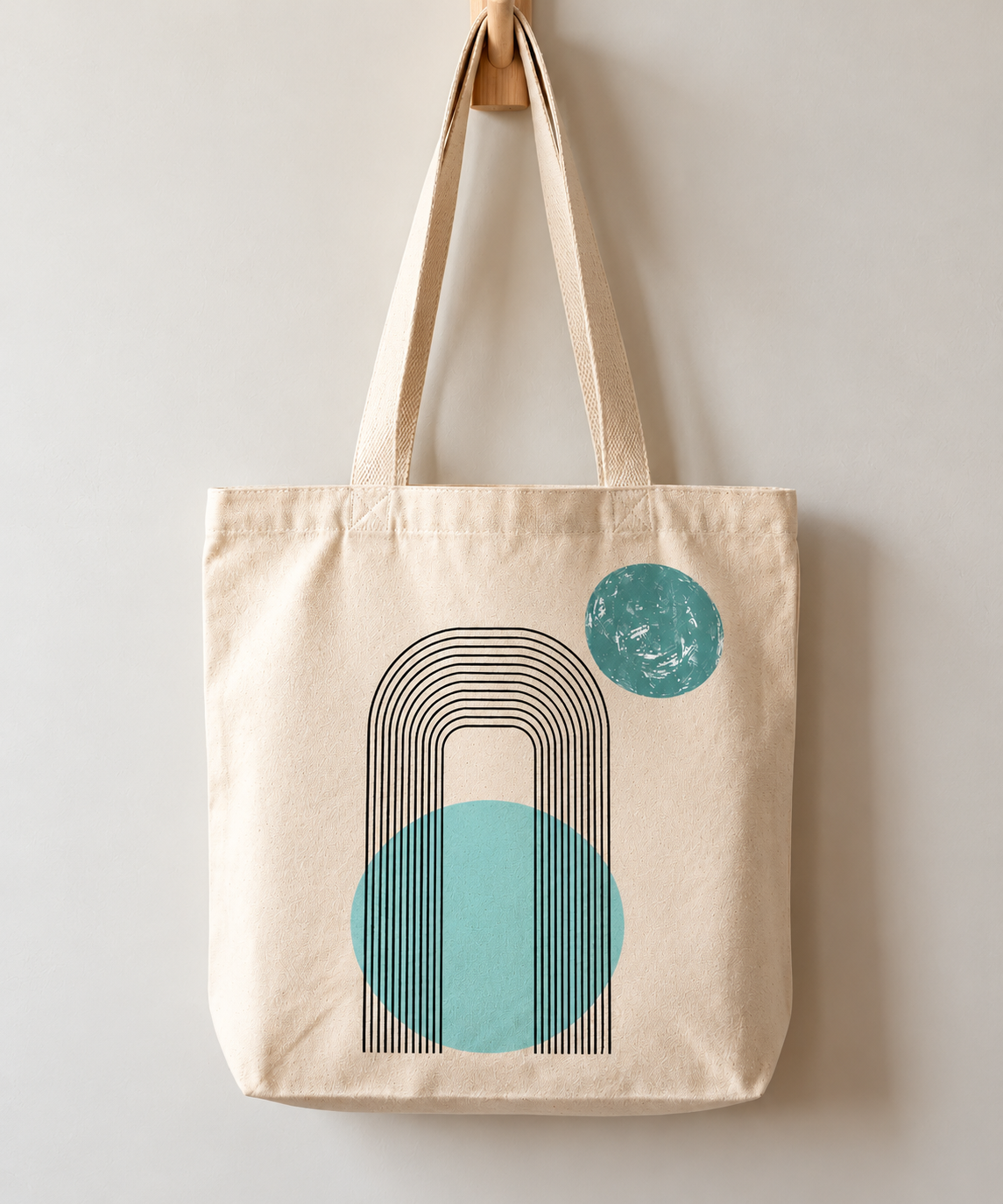 Natural-colour tote bag with fine black arch lines and two textured teal circles.