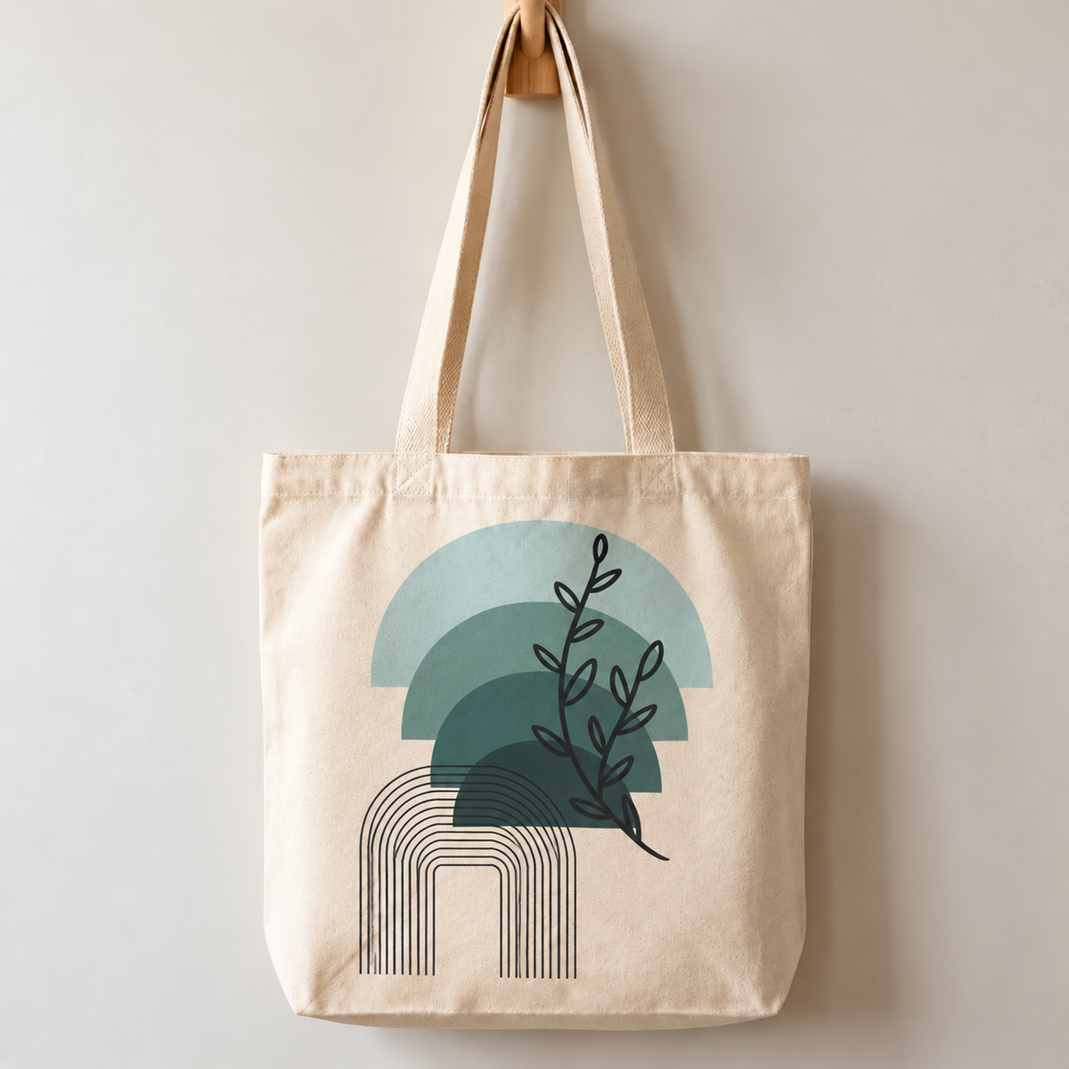 Natural-colour tote bag with layered teal arches, a black botanical sprig and fine black arch lines.